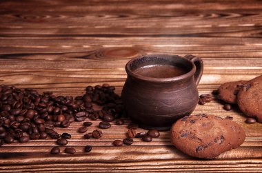 Kil Kupası ahşap bir masa üzerinde kahve çekirdekleri ile