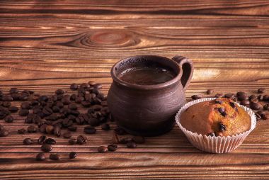 Kil Kupası ahşap bir masa üzerinde kahve çekirdekleri ile