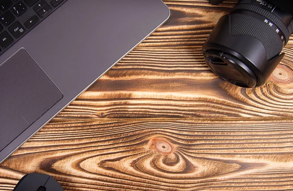 laptop, mouse and camera on a wooden table