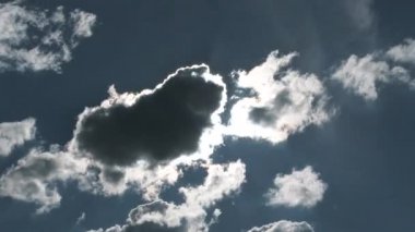 Time lapse of shining star revealing behind dark cloud and rising in blue sky.