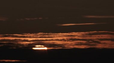 Sunrise timelapse from dark to warm lit and cloudy sky, close up.