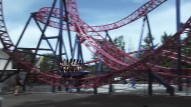 People at amusement park have fun riding on rollercoaster.