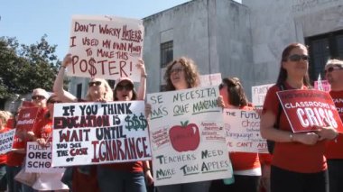 Hundreds of teachers and students chant for more school funding outside the State Capitol Building.