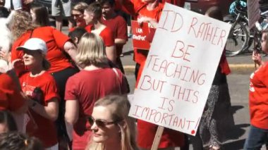 Teacher holding sign reading 