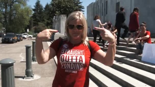 Kobieta Ubrana Koszulę Czytająca Straight Outta Funding Stoi Przed Budynkiem — Wideo stockowe