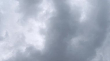 Dark stormy clouds swirl in sky with rain starting to fall and drop on camera lens, time lapse.