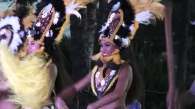 Group of male and female hula dancers perform traditional dance at luau on the Hawaiian Islands.
