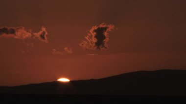 Real time sunset behind hillside showing final light before night.