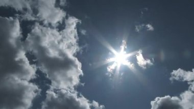 Wide angle cloudscape time lapse of blue sky day and clouds passing as sun shines bright through cloud breaks.