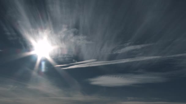 様々な雲が通り過ぎる青空に照りつける太陽 — ストック動画