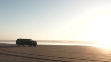 Kamyon, güneşli bir günde Oregon 'daki kumlu sahilden geçiyor..