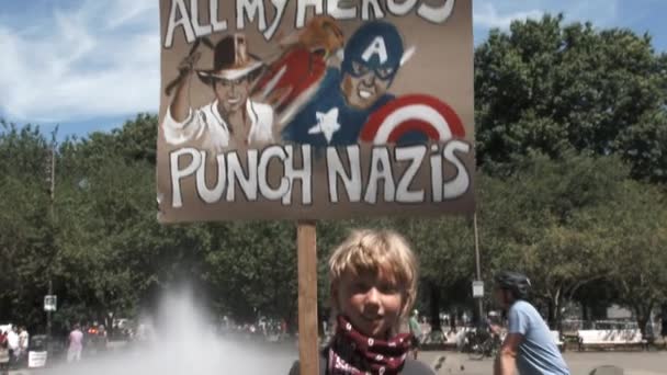 在市中心的一次特朗普集会上 一个拿着写着 我所有英雄都打纳粹 字样的标牌的小男孩展示了自己的立场 — 图库视频影像