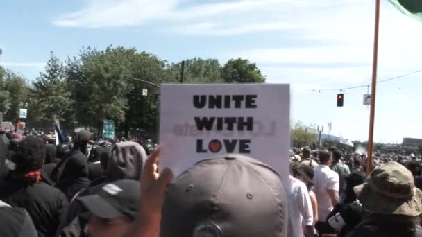 Person Holding Sign Reading Unite Love Protest White Nationalists Downtown — Stock Video