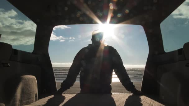 Homem Silhueta Senta Parte Trás Carro Relaxando Praia Enquanto Observa — Vídeo de Stock