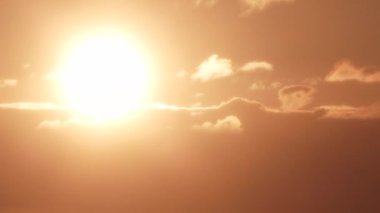 Ilık gökyüzünde, bulutların üzerinde parlayan parlak güneşe yaklaş..