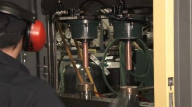 Fabrikada çalışan makinist bakır parçaları üretiyor..