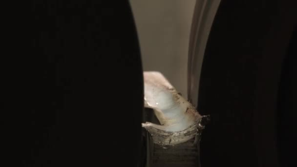 Boucle clip gros plan de la personne qui alimente les pièces en cuivre à travers la machine de ponçage du métal à une finition lisse .