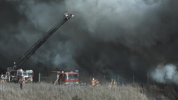 在大风造成黑烟的情况下 消防队员努力控制住大火 因此他们的工作被取消了 — 图库视频影像