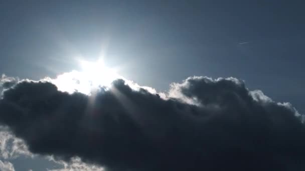 Le soleil brille le jour du ciel bleu avec des nuages se déplaçant rapidement passant par que le soleil tombe, timelapse .