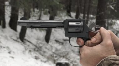 Adam ormanda tabancayla ateş ederken hedefini vururken sayıyor..