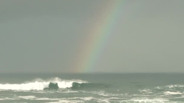 大浪在汹涌的海面上冲撞 彩虹高过地平线 鸟儿在暴风雨来临时掠过船架 — 图库视频影像