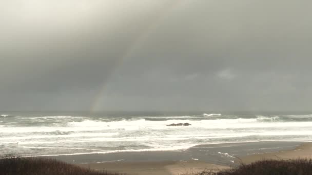 嵐の日にオレゴン州の太平洋岸で波がクラッシュし 海の地平線に虹が — ストック動画