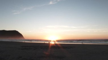 Gün batımında kumlu sahilde çekim yapmak ya da gündoğumunda insanların manzaranın tadını çıkarması..