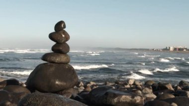 Oregon sahilinde kayalar dengede ve okyanus dalgaları arkadan çarpıyor..