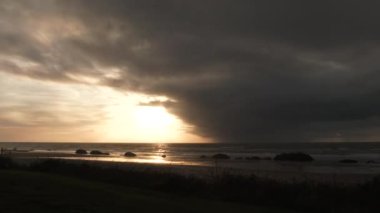 Oregon Sahili 'nde gün batımının güzel zamanlaması. Fırtına bulutu okyanus ufkunun altından geçerken geçiyor..