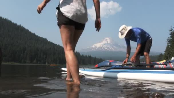 在夏天的日子里 一对年长的夫妇带着划桨板到湖边 — 图库视频影像