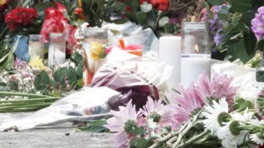 Portland, Oregon 'daki bıçaklama trajedisi kurbanlarının anısına sokaklarda sergilenen bir sürü çiçekle mumlar yanıyor..