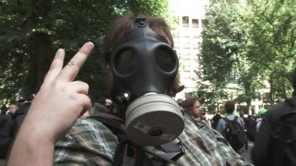在波特兰市中心举行的抗议活动中 戴着防毒面具的人手持和平标志向摄像机致敬 — 图库视频影像