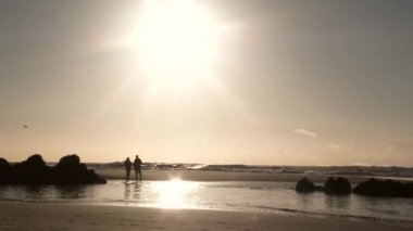 Çiftler Oregon kıyısındaki kumsalda güneşli bir günün tadını çıkarıyorlar..