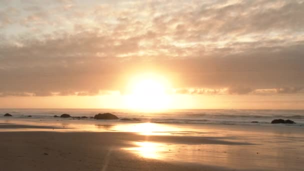 太陽が明るくカラフルな雲が空を満たし 広い角度で輝く日没の間にオレゴン海岸での時間の経過 — ストック動画
