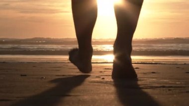 Model serbest bırakılan kişi kumlu sahilde ve güzel güneşli bir gecede Oregon Sahili 'nde Pasifik' e doğru yürüyor..