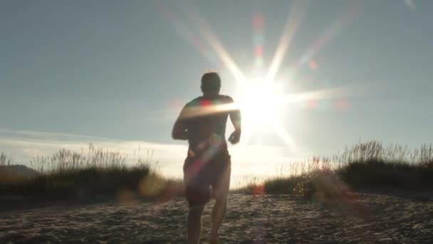 美しい晴れた日にオレゴン海岸で砂丘を駆け上がる人 — ストック動画