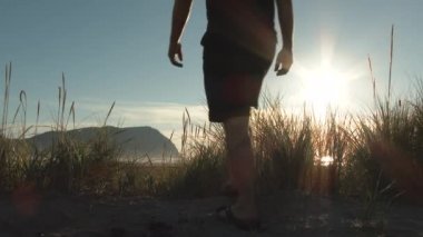 İnsan güzel bir günde Oregon 'da sahil kenarındaki kum tepelerinden kumlu kumsala doğru yürür..