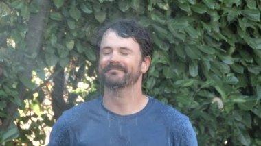 Model üzerinde ağır çekim serbest bırakılan adam sıcak bir günde dışarıda duruyor ve kendini iyi hissediyor..