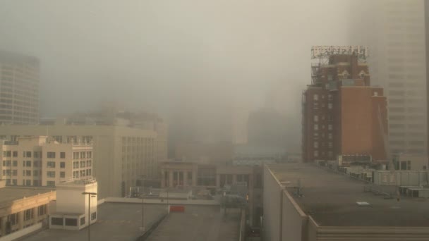 都心部のビルの中に濃霧が巻きつく — ストック動画