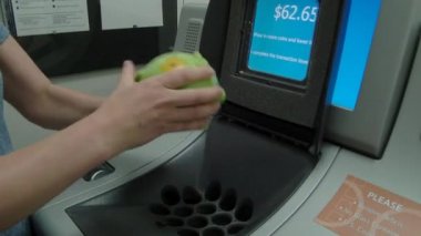 Bankadaki biri kumbaradan makineye bozuk para boşaltıyor..
