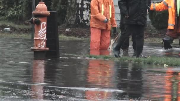 オレゴン州ポートランドで雨の嵐の間 浸水した通りに立っている認識できない人々 — ストック動画