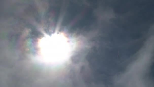 雲の後ろに輝く太陽は青い空を通して燃える — ストック動画