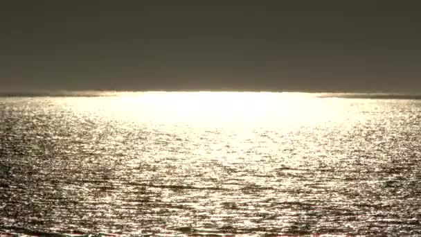 太陽は太平洋岸の海の地平線に明るい光を反射して輝いています — ストック動画