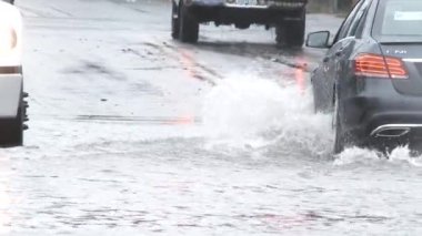 Portland, Oregon 'da yağmur fırtınasından sonra su basmış caddelerde derin su birikintilerinden geçen araçlar.