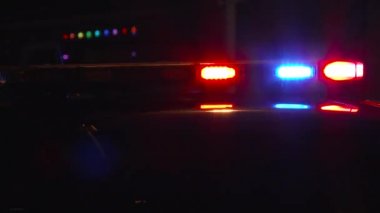 Polis ışıkları gece olay yerinde yanıp sönüyor. Arabalar geçiyor..