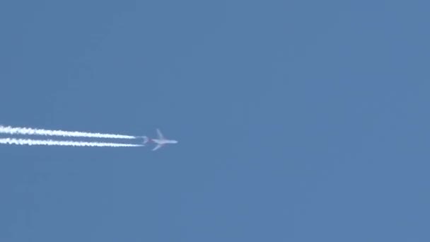 L'avion vole au-dessus du cadre par temps clair et bleu laissant derrière lui des traînées de vapeur, des traînées de jet .