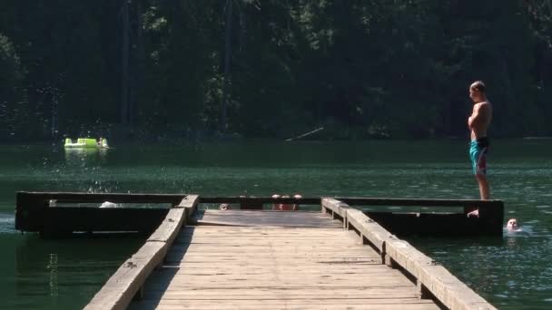 Ragazzi Che Scappano Giù Molo Legno Rinfrescarsi Saltando Nel Lago — Video Stock