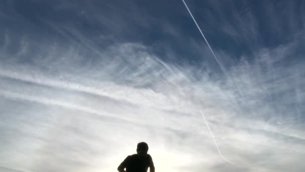 モデルリリース 男のシルエットを山頂まで青い空を見上げに登る — ストック動画
