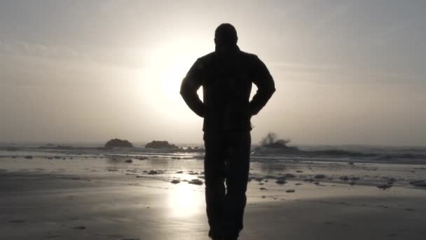 在俄勒冈州海岸 一个轮廓轮廓轮廓清晰的男人走在日落前美丽的沙滩上 — 图库视频影像