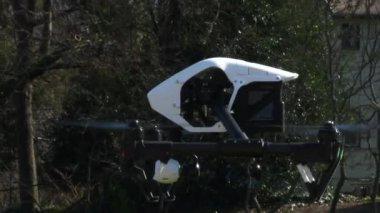Kuadkopter ya da kuadrotor olarak da bilinen büyük, profesyonel insansız hava aracı Portland, Oregon 'daki şehir parkında havalanıyor. 4K 'da yakalandılar..